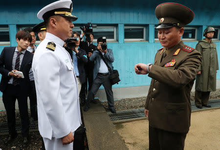 A North Korean military official looks at his watch as he leads South Korean military officials near the concrete border at the northern side of the truce village of Panmunjom, in North Korea, June 14, 2018. Yonhap via REUTERS