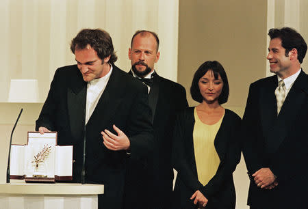 Director Quentin Tarantino reacts after winning the Palme d'Or award for his film "Pulp Fiction" as actor Bruce Willis, actress Maria de Medeiros, and actor John Travolta look on during the closing ceremony at the 47th Cannes Film Festival, in Cannes, France, May 23, 1994. REUTERS/Eric Gaillard/File Photo
