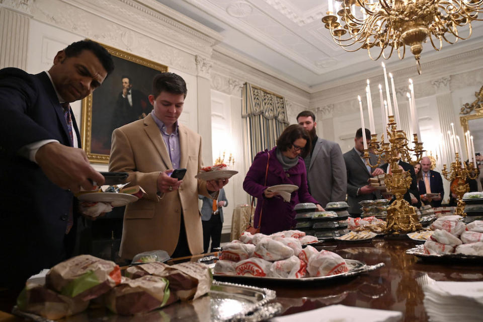 Guests attending a reception for the Clemson Tigers grab fast food sandwiches in the State Dining Room of the White House (Picture: AP)