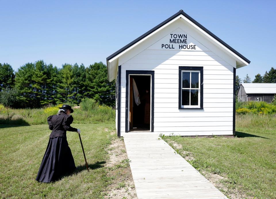 A woman dressed in a 19th Century dress walks to the Town Meeme Poll House at Pinecrest Historical Village, Saturday, August 14, 2021, in Manitowoc, Wis.