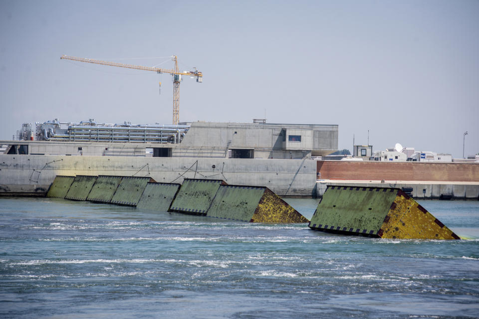 Moveable flood gates rise from the sea in the Venice lagoon, Italy, Friday, July 10, 2020. Venice has conducted a trial run an ambitious anti-flood system of 78 inflatable barriers in the hopes of protecting the lagoon city from devastating high tides. Premier Giuseppe Conte on Friday at a ceremony in Venice pressed a button that activated compressors to pump air into the bright yellow barriers, which then started rising from the sea to act a kind of a dike-on-demand. (Claudio Furlan/LaPresse via AP)