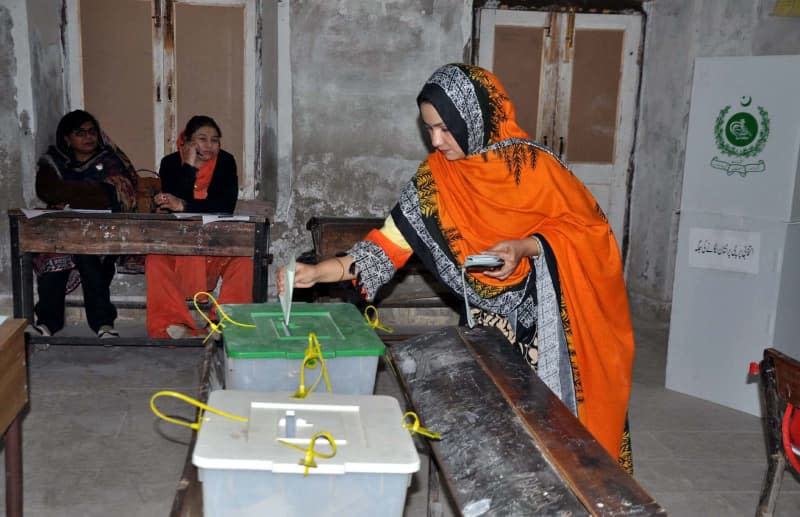 A woman casts her vote inside a polling station during the 2024 Pakistani general election. -/PPI via ZUMA Press Wire/dpa