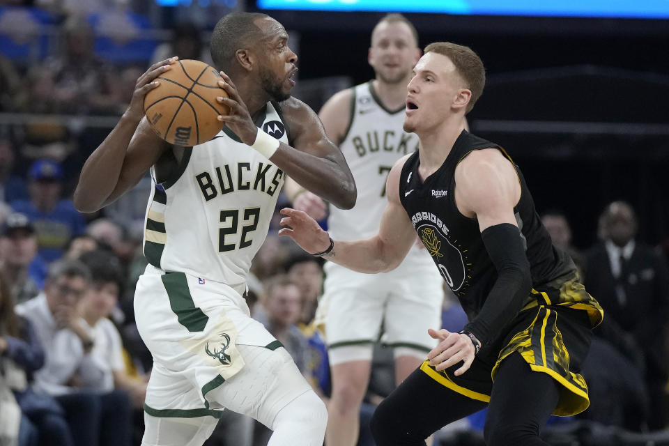 Milwaukee Bucks forward Khris Middleton (22) looks to pass the ball while being defended by Golden State Warriors guard Donte DiVincenzo during the first half of an NBA basketball game in San Francisco, Saturday, March 11, 2023. (AP Photo/Jeff Chiu)