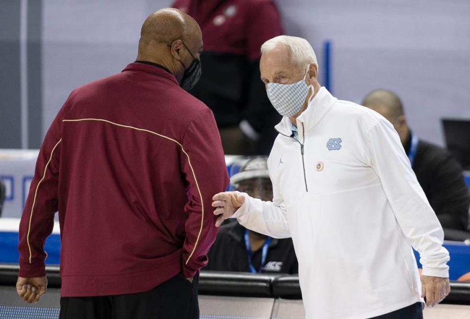North Carolina coach Roy Williams talks with Florida State coach Leonard Hamilton prior to a 2021 game. Although Hamilton, 75, is two years older than Williams, Hamilton is still coaching, while Williams retired from UNC in 2021.