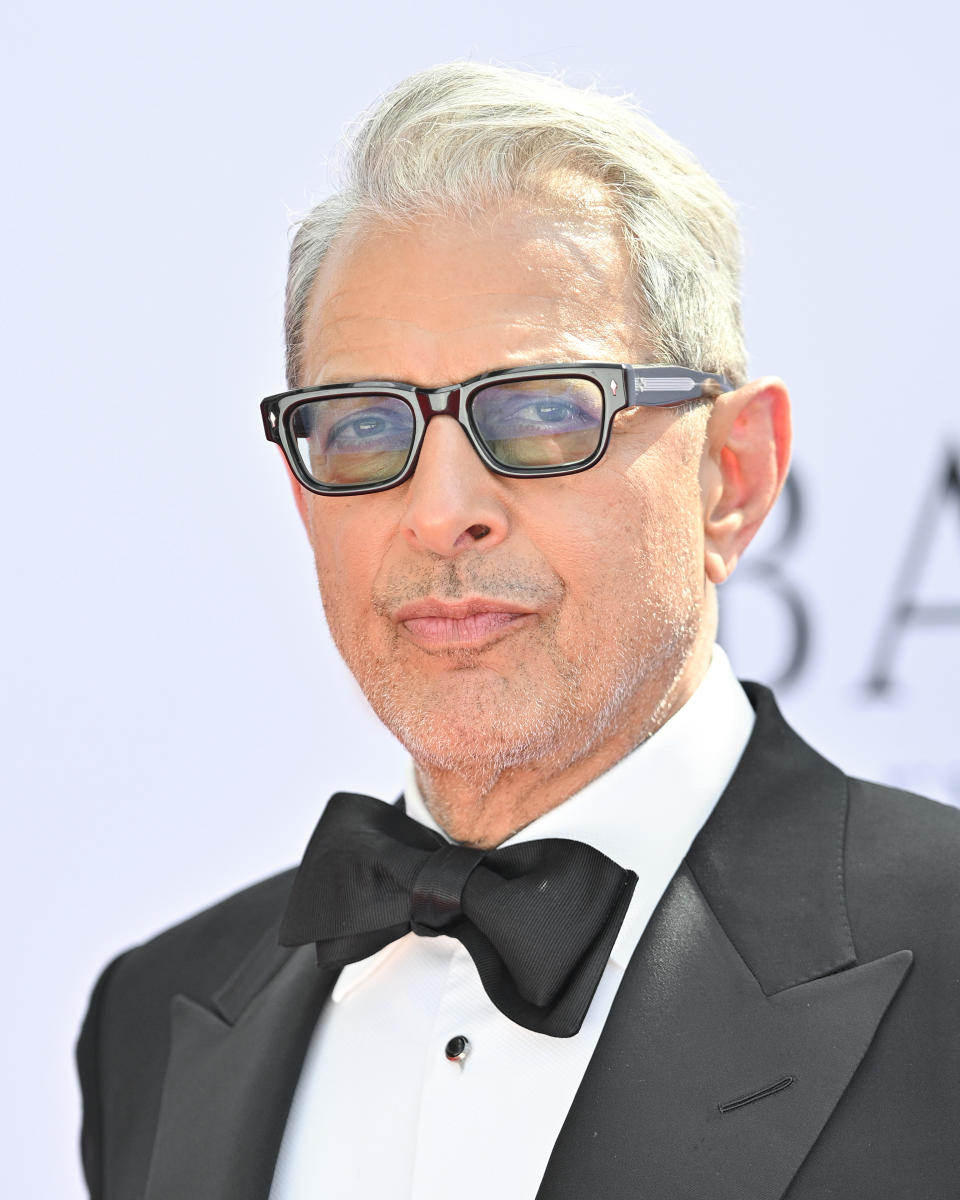 Jeff Goldblum wearing a black tuxedo, white dress shirt, black bow tie, and thick-rimmed glasses at a formal event