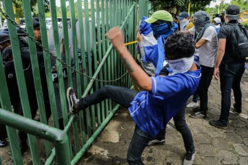 An anti-government protester kicks a riot police shield during a demonstration at the Central American University on November 19