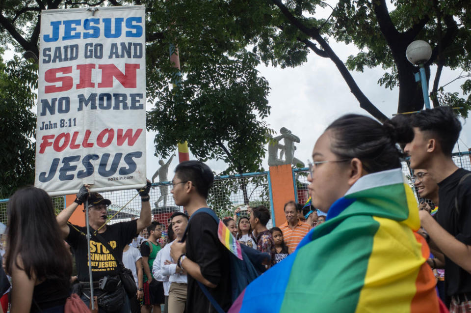 Members of the lesbian, gay, bisexual, and transgender (LGBT) community walk past a religious heckler during the annual LGBT pride celebration in Marikina City, east of Manila, Philippines, on 30 June 2018.<span class="copyright">Richard James Mendoza—NurPhoto/Getty Images</span>