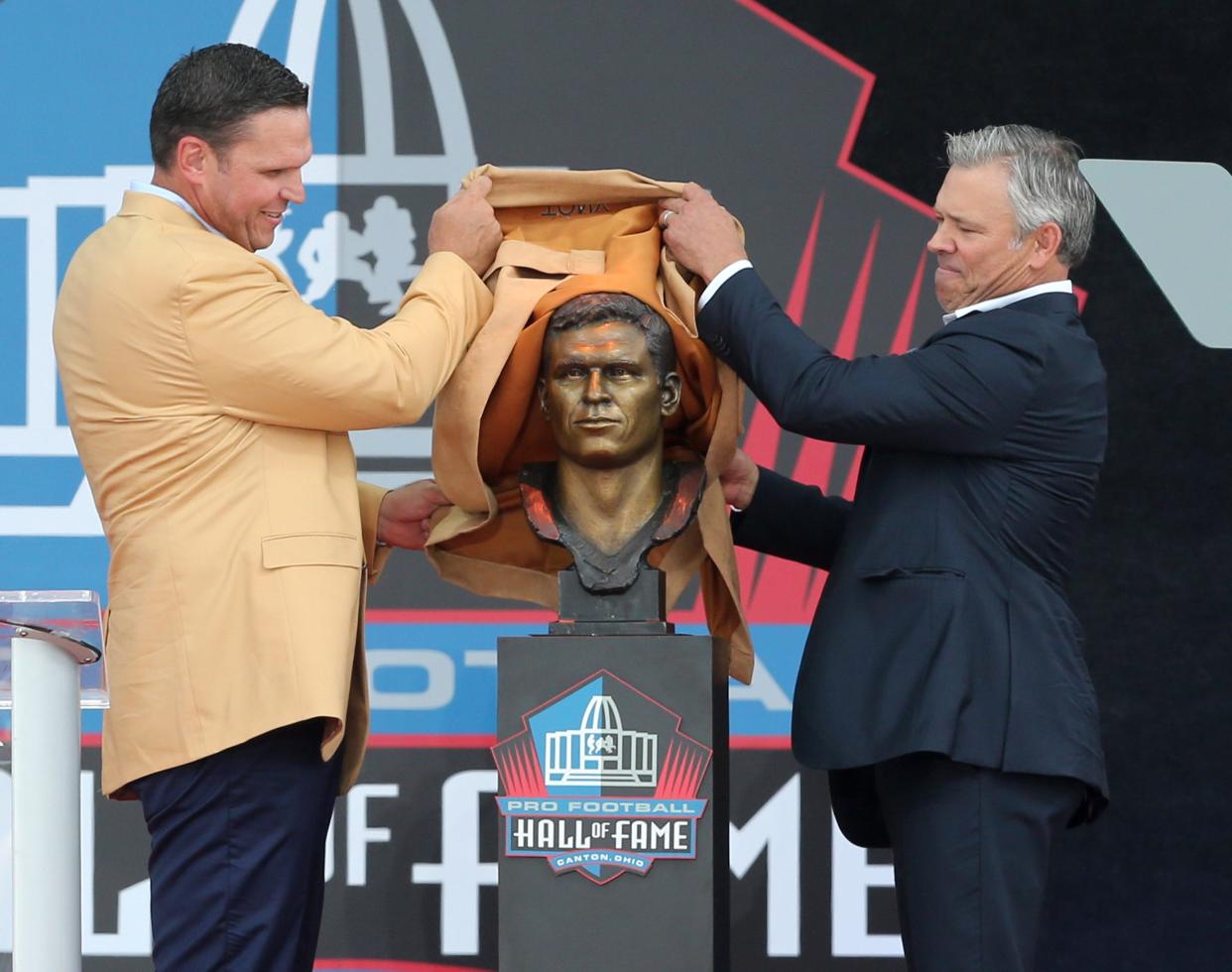Tony Boselli, left, and his presenter Mark Brunell, right, unveil Boselli's bust during the Pro Football Hall of Fame Enshrinement at Tom Benson Stadium in Canton on Saturday, August 6, 2022.