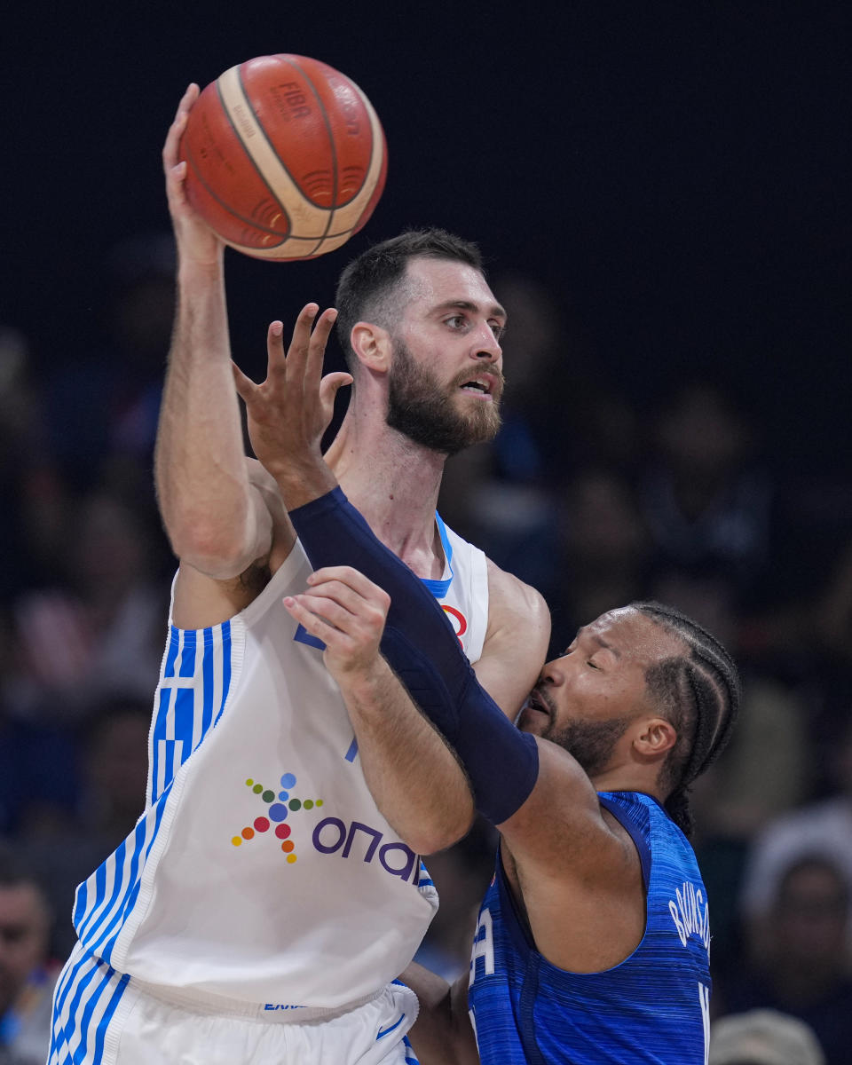 Greece center Georgios Papagiannis (14) is defended by U.S. guard Jalen Brunson (11) during the first half of a Basketball World Cup group C match in Manila, Philippines Monday, Aug. 28, 2023.(AP Photo/Michael Conroy)