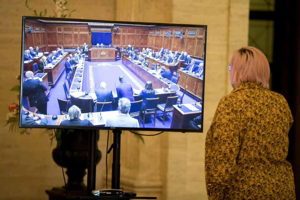 A Stormont official watches proceedings in the Northern Ireland Assembly Chamber on a television in the Great Hall at Stormont Buildings (Liam McBurney/PA)