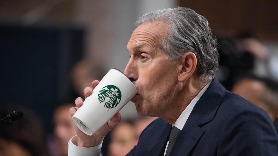 Former Starbucks CEO Howard Schultz drinks coffee during a Senate Health, Education, Labor, and Pension Committee hearing.