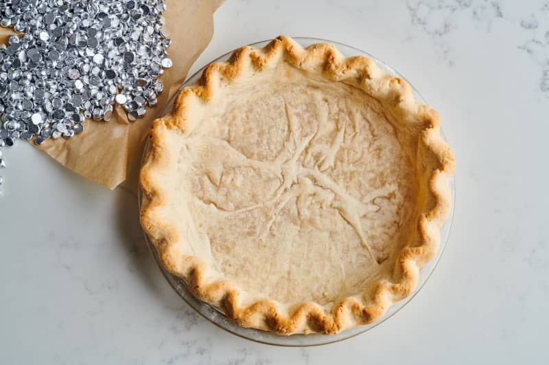 pie crust in tin sits next to loose metal weights