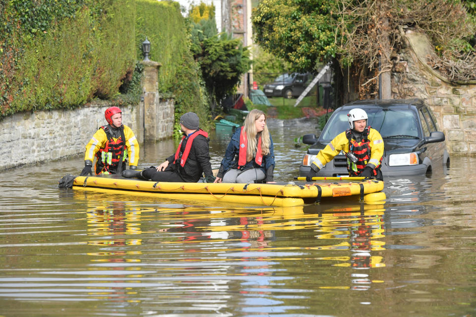 Members of Gloucestershire Fire & Rescue Service rescue residents stranded in flood water from the River Wye in Lower Lydbrook, Gloucestershire.