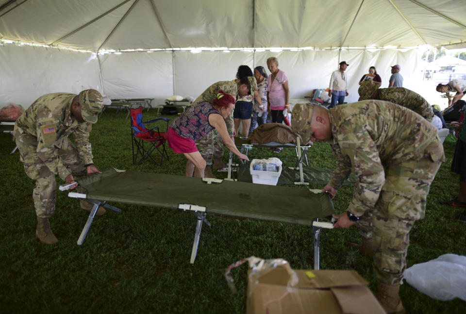 Miembros del ejército de Estados Unidos montan un catre mientras colocan una carpa para albergar a cientos de personas que se quedaron sin un hogar por un sismo, en Guánica, Puerto Rico, el martes 14 de enero de 2020. (AP Foto/Carlos Giusti)