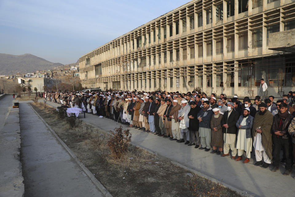 CORRECTS DATE OF ATTACK AND IDENTIFIES RASHEED AS THE HEAD OF THE INDEPENDENT ELECTIONS WATCHDOG - Villagers offer prayers over the coffin of Mohammad Yousuf Rasheed, executive director of the non-governmental Free and Fair Election Forum of Afghanistan, during his funeral ceremony, in Kabul, Afghanistan, Wednesday, Dec. 23, 2020. Separate bombing and shooting attacks in Afghanistan’s capital left several people dead Wednesday, including Rasheed, the head of the independent elections watchdog, officials said. (AP Photo/Rahmat Gul)