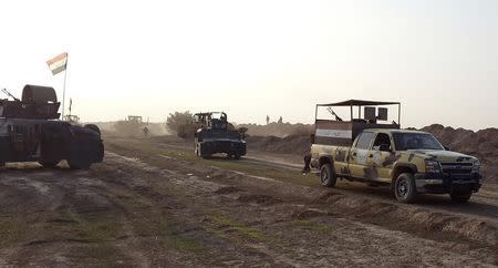 Iraqi security forces guard during the building of a new road between Diyala province and Samarra December 21, 2014. REUTERS/Stringer