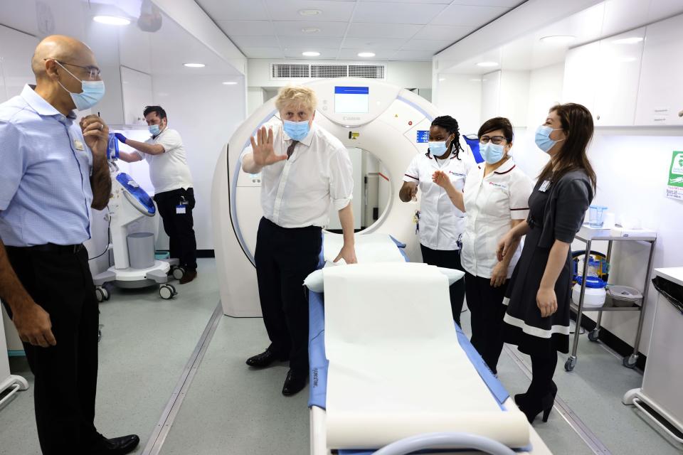 Britain's Prime Minister Boris Johnson, centre, gestures, during a visit to Finchley Memorial Hospital, in North London, Tuesday, Jan. 18, 2022. (Ian Vogler, Pool Photo via AP)