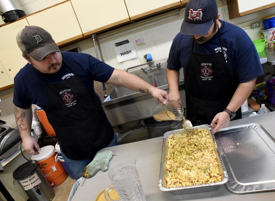 Monroe Firefighter/paramedics Matt Tata and Frank Palumbo put the final touches on the stuffing, which was part of the Thanksgiving meals they provided for pickup at Oaks Village in Monroe Wednesday, November 24, 2021.