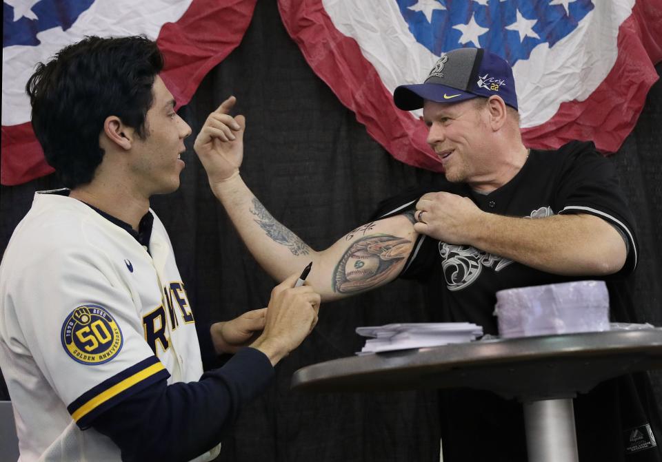 Christian Yelich signs the bicep of Oconomowoc's Kevin Karenz on Jan. 26, 2020, during "Brewers On Deck" at the Wisconsin Center.