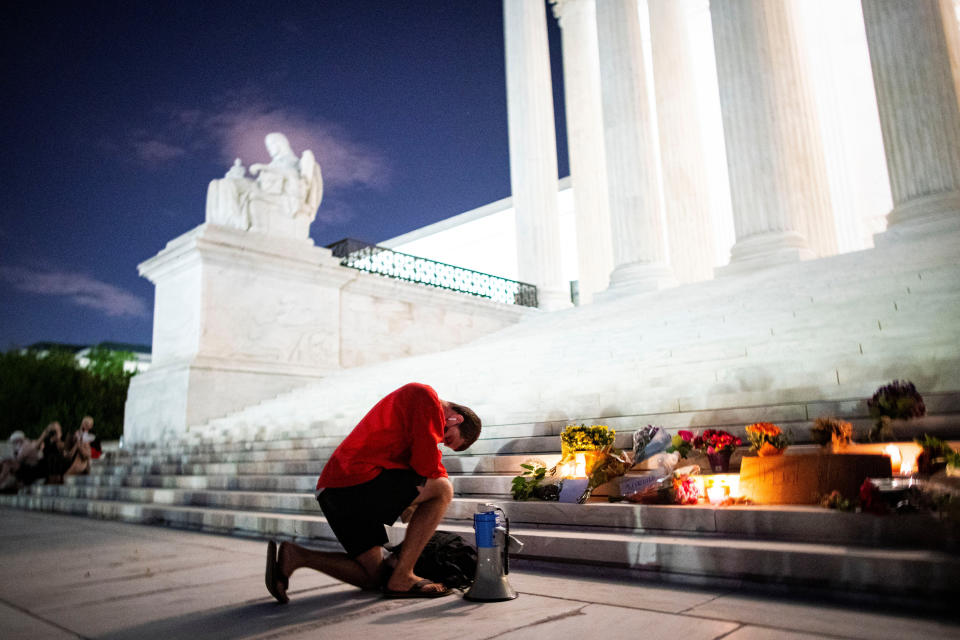Image: A man kneels as he brings a megaphone to a vigil on the steps of the U.S. Supreme Court following the death of U.S. Supreme Court Justice Ruth Bader Ginsburg, in Washington (Al Drago / Reuters)