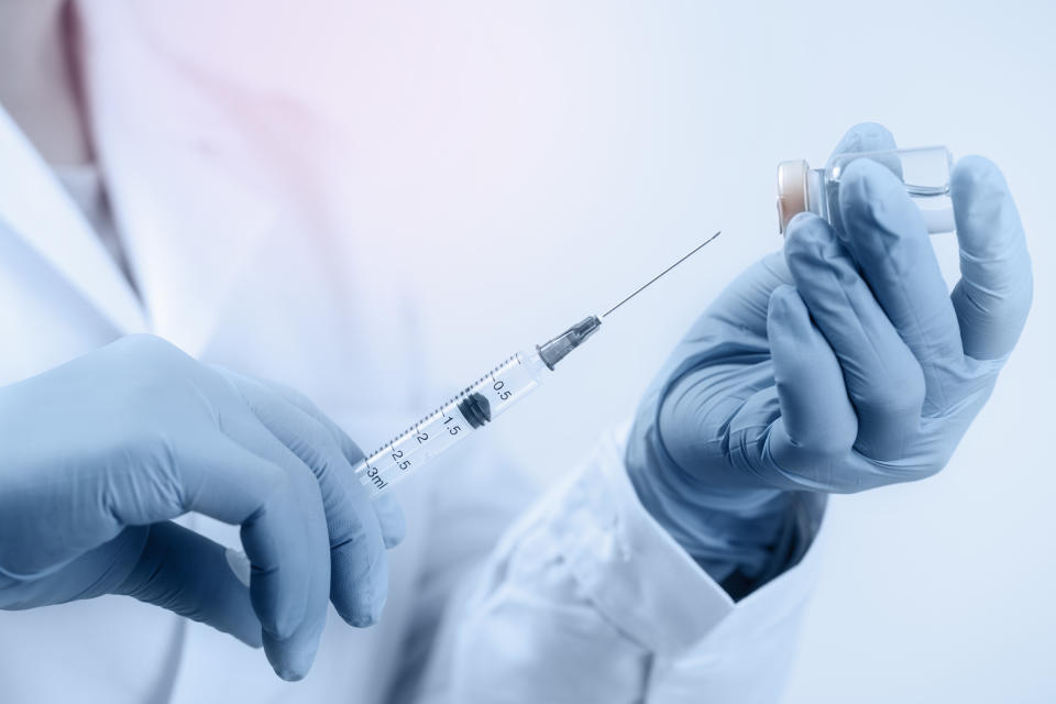Hand holding syringe and medicine vial prepare
