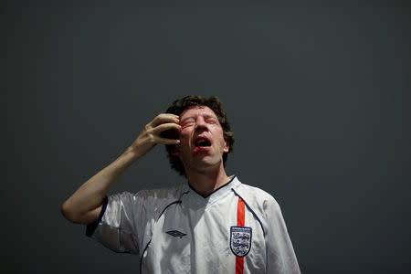 British performance artist Bill Aitchison rubs an onion across his face as he performs his piece "Tears of a Loyal Patriot" at the OPEN international performance art festival in the Songzhuang art colony outside Beijing, China, September 22, 2017. REUTERS/Thomas Peter