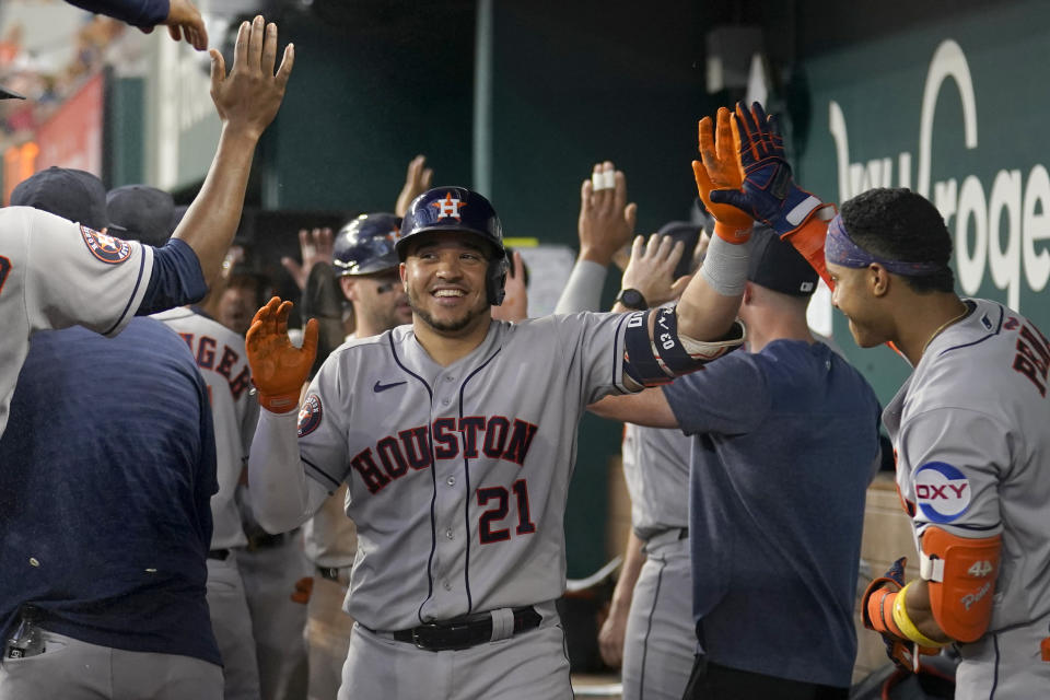 Houston Astros' Yainer Diaz (21) celebrates in the dugout with teammates after connecting for a three-run home run in the seventh inning of a baseball game against the Texas Rangers, Monday, Sept. 4, 2023, in Arlington, Texas. Jose Abreu and Chas McCormick also scored on the shot. (AP Photo/Tony Gutierrez)