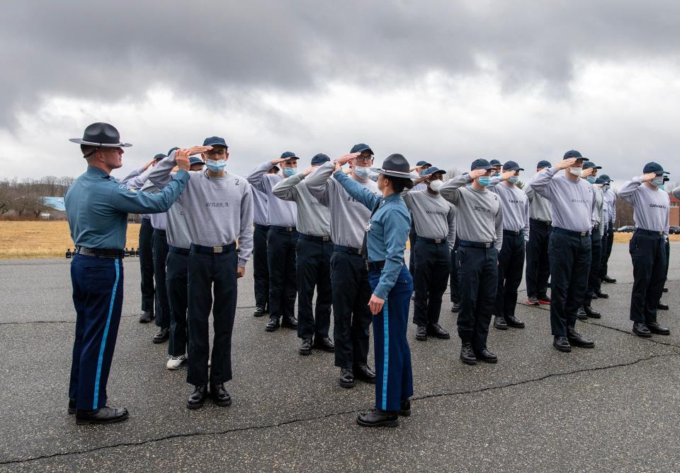 Trooper Michael Pacheco and Trooper Haley Erickson instruct recruits on the proper hand angle for a salute Tuesday at the Mass. State Police Academy in New Braintree.