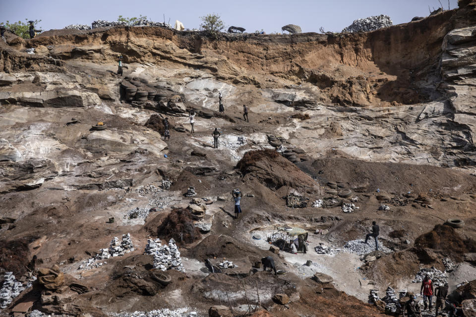 People work in a Pissy granite mine in Ouagadougou, Burkina Faso, Wednesday April 27, 2022. he influx of people displaced by the country's rapidly rising Islamic violence is causing competition among the approximately 3,000 people working at the granite mine. At least 500 displaced people started working at the mine last year making it harder for the original miners to earn a living, said Abiba Tiemtore, head of the site. (AP Photo/Sophie Garcia)