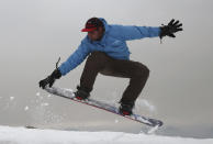 In this Friday, Jan. 24, 2020 photo, Nizaruddin Alizada, 20, a member of the Afghanistan Snowboarding Federation practices on the hillside known as Kohe Koregh, on the outskirts of Kabul, Afghanistan. While Afghanistan’s capital may seem an unlikely destination for snowboarders, a group of young Afghans is looking to put the city on the winter sports map and change perceptions about their war-weary nation. (AP Photo/Rahmat Gul)