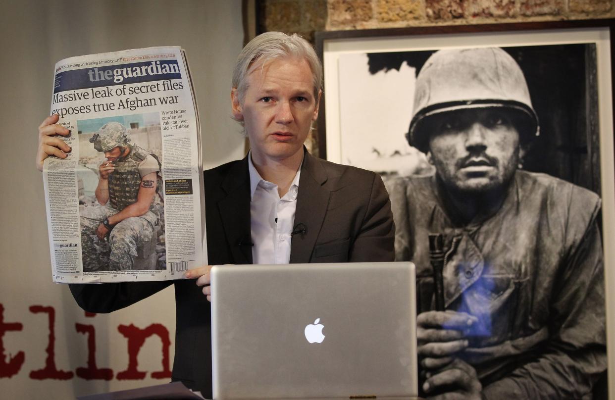 Julian Assange of the WikiLeaks website holds up a copy of The Guardian newspaper as he speaks to reporters in front of a Don McCullin Vietnam war photograph at The Front Line Club on July 26, 2010 in London, England. The WikiLeaks website has published 90,000 secret US Military records. The Guardian and The New York Times newspapers and the German Magazine Der Spiegel have also published details.