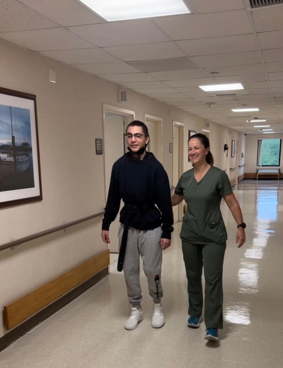 Lawton Chiles High School senior Owen Horton walks with a caregiver. He will be graduating May 25, 2023 after undergoing a critical recovery journey in the past several months due to severe injuries from a single-vehicle car crash.