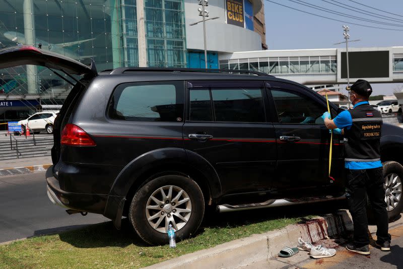 Police officers inspect a victim's vehicle in front of the Terminal 21 shopping mall following a gun battle involving a Thai soldier on a shooting rampage, in Nakhon Ratchasima