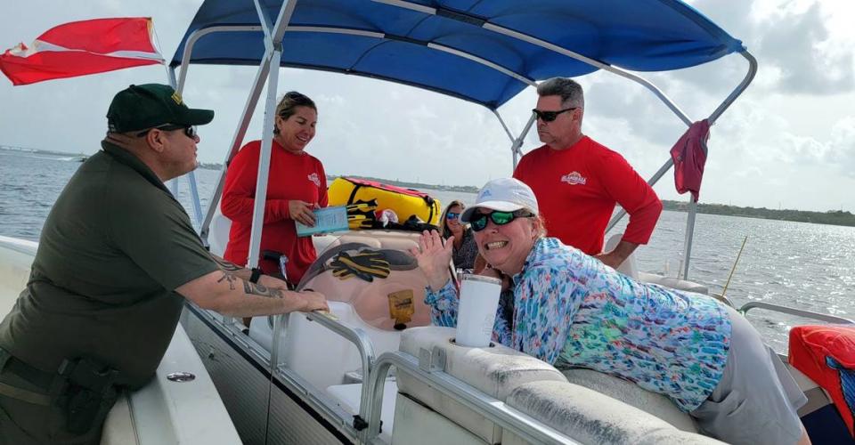 Monroe County Sheriff’s Office Upper Keys Detective Sgt. Nick Whiteman and Detective Matt O’Neill check a lobster catch on July 27, 2022. In this case, these anglers had expired flares and were only given a warning.