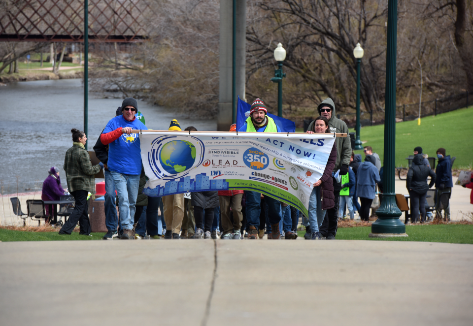 Environmental advocates march from Fawick Park to Sioux Falls City Hall on Saturday, April 22, 2023. SoDak 350, a nonpartisan grassroots group, organized a rally in response to a revised sustainability plan they say lacks definitive action for combating climate change.
