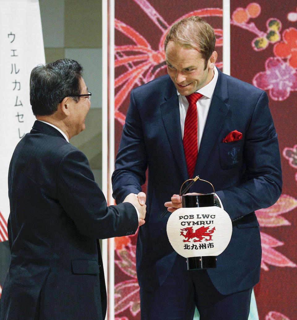 Wales' captain Alun Wyn Jones, right, receives a souvenir lantern during the welcome ceremony in Kitakyushu, western Japan, Monday, Sept. 16, 2019, ahead of the Rugby World Cup in Japan. (Kyodo News via AP)