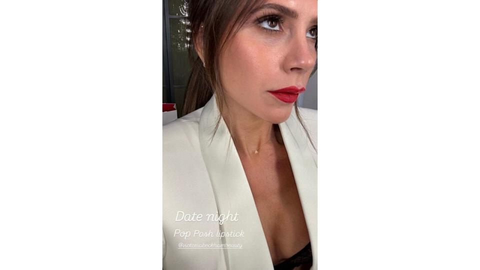 Victoria Beckham wearing a white suit and red lipstick