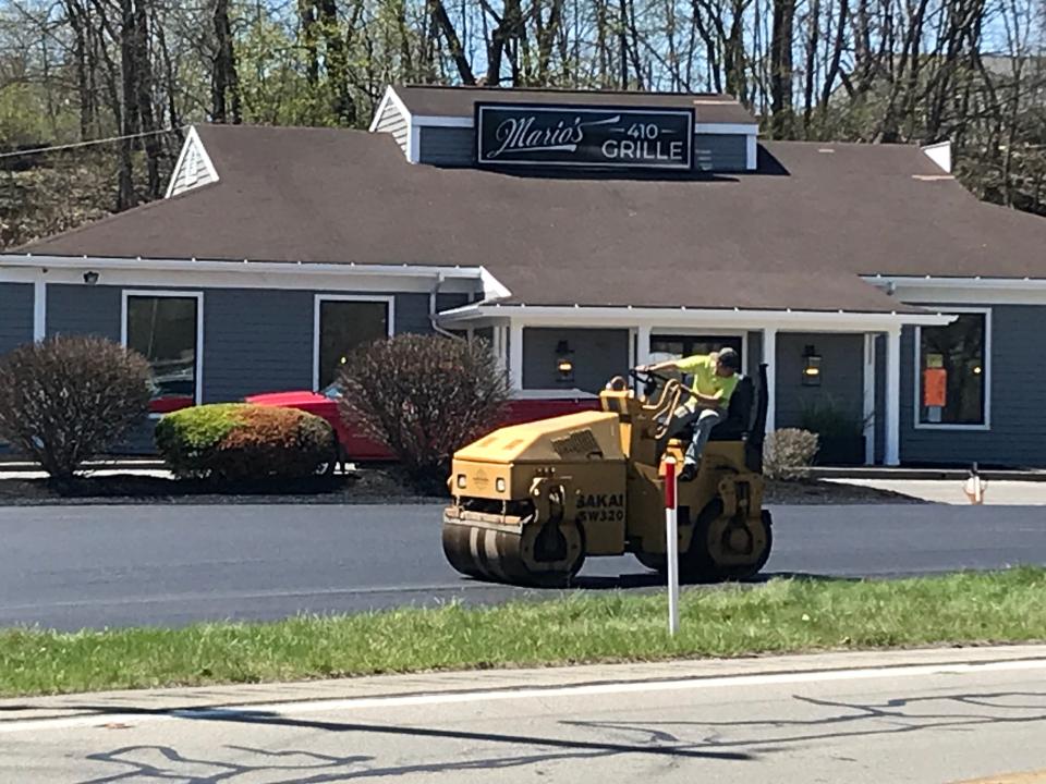 A worker paves the parking lot Monday at Mario's 410 Grille in Bridgewater.