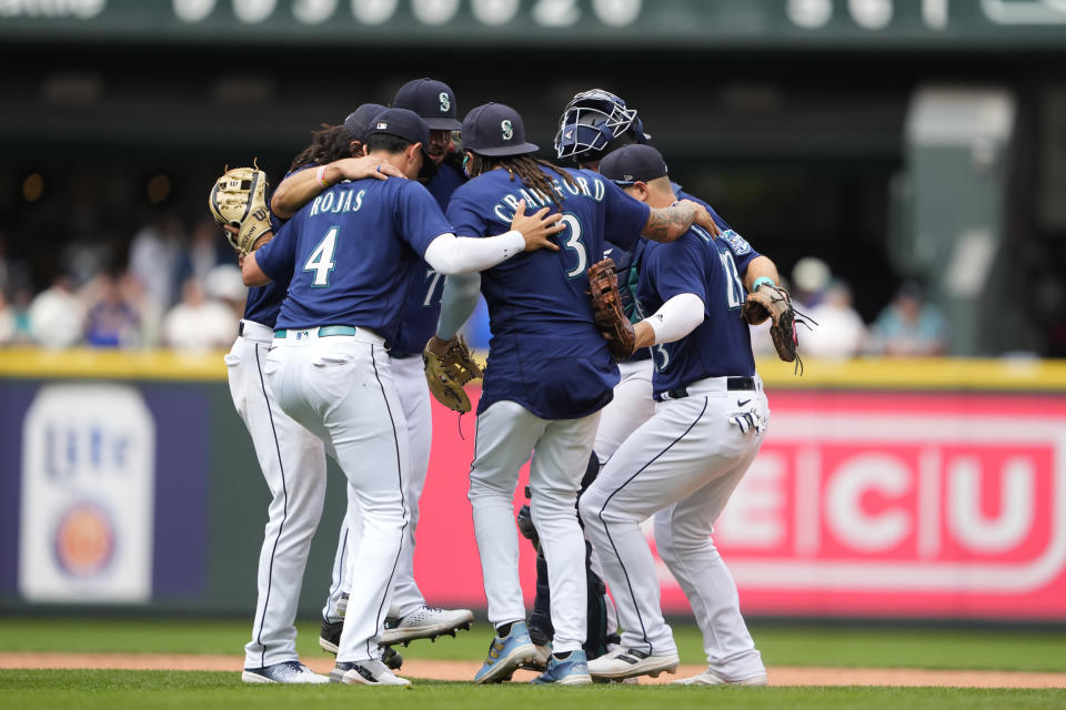 Seattle Mariners' Josh Rojas (4), J.P. Crawford (3), Ty France (23) and others celebrate a 5-4 win over the Oakland Athletics in a baseball game Wednesday, Aug. 30, 2023, in Seattle. (AP Photo/Lindsey Wasson)