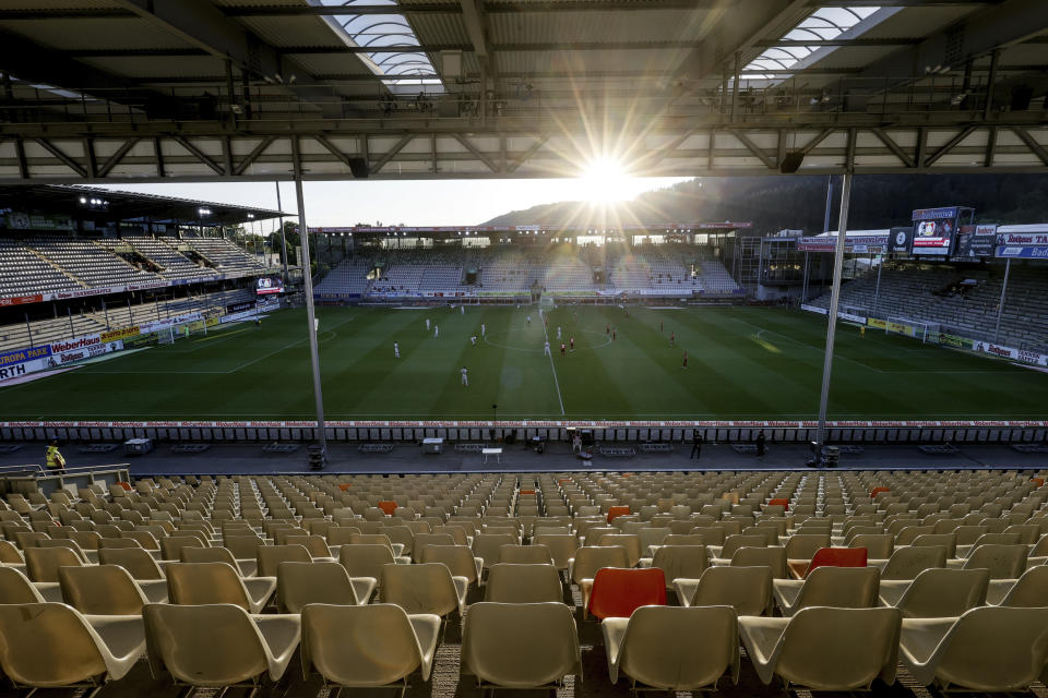 Soccer players play front of empty stands during the German Bundesliga soccer match between SC Freiburg and Bayer 04 Leverkusen in Freiburg, Germany, Friday, 29 May, 2020. Because of the coronavirus outbreak all soccer matches go the German Bundesliga without spectators. (Ronald Wittek/Pool via AP)