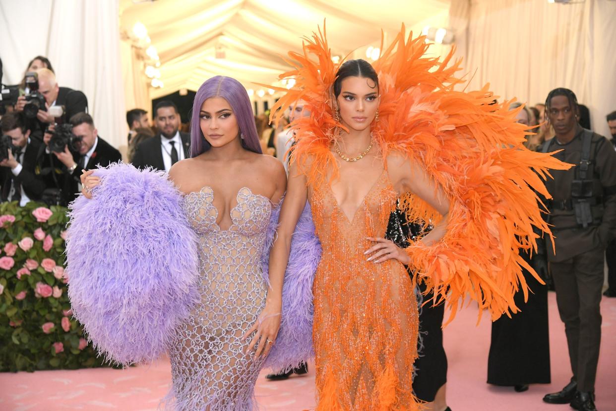 Kylie Jenner (left) and Kendall Jenner (right) wearing extravagant purple and orange camp dresses for the MET gala 