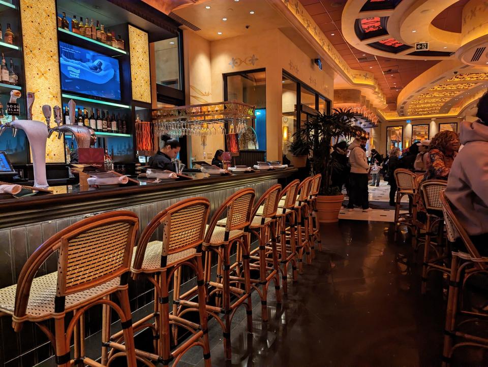 bar seating at the cheesecake factory with cane chairs and dim lights