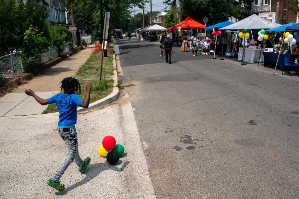 WASHINGTON, DC - JUNE 17: Jamboree Thomas, 8, kicks Juneteenth-themed balloons down the street during a neighborhood Juneteenth festival on June 17, 2023 in Washington, DC. Two years ago, President Joe Biden signed bipartisan legislation establishing Juneteenth as a federal holiday. Juneteenth commemorates the day on June 19, 1865 when a Union general read orders in Galveston, Texas stating all enslaved people in the state were free according to federal law.
