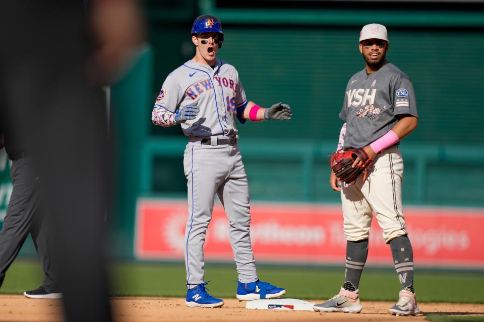 New York Mets' Mark Canha reacts after an RBI double as he stands on second base near Washington Nationals second baseman Luis Garcia during the fifth inning of a baseball game at Nationals Park, Sunday, May 14, 2023, in Washington. (AP Photo/Alex Brandon)