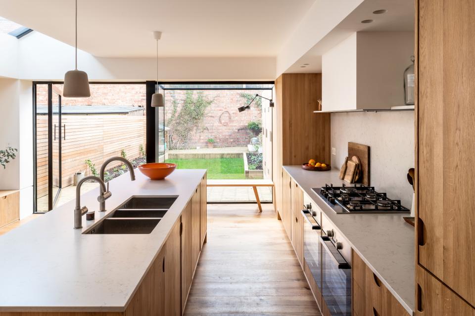 A single, massive pivot door opens the kitchen up to the backyard.