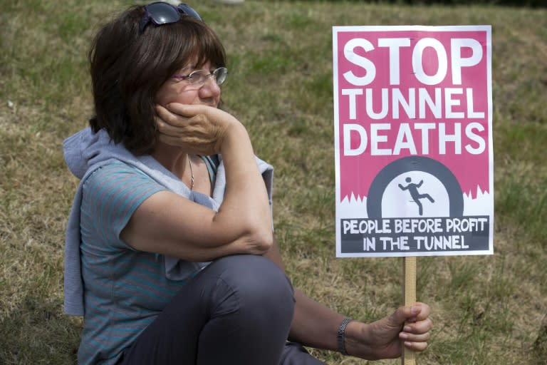 A protester waits with a sign outside an entrance to the Eurotunnel terminal in Folkestone, England on August 1, 2015