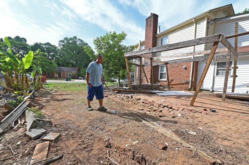 Jay Chhoeun walks through the damaged area of his yard on Tuesday, April 30, 2024. Chhoeun’s home is next to 5525 Galway Drive where three members of the U.S. Marshals task force and a CMPD Officer Joshua Eyer were killed on Monday, April 29, 204 when they were serving a warrant to the suspect. Four other officers were wounded during the shooting.