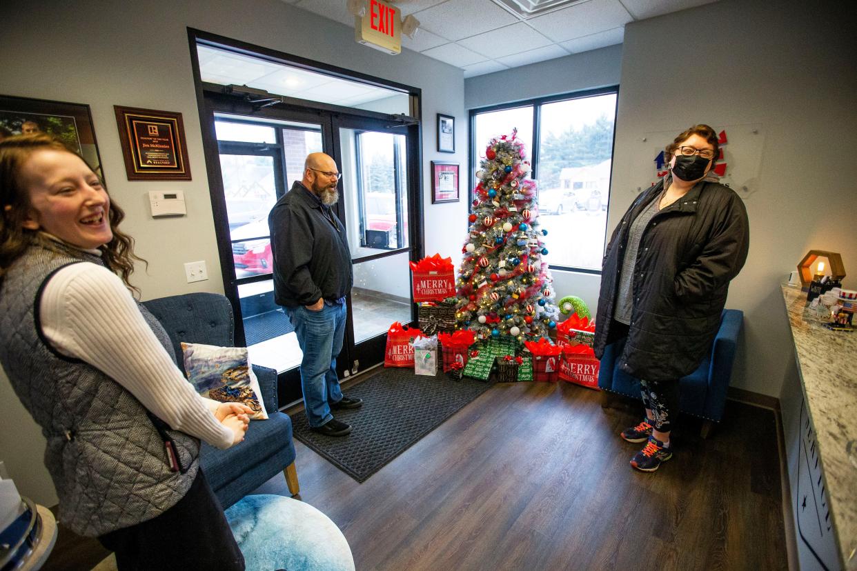 Emily Koszyk with Homes for Heroes shares a laugh with Aaron and Claudine Miller Tuesday, Dec. 7, 2021 at McKinnies Realty in Mishawaka.