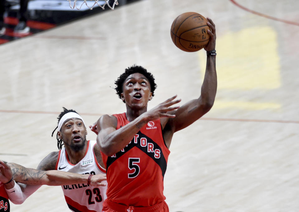 Toronto Raptors forward Stanley Johnson, right, drives to the basket past Portland Trail Blazers forward Robert Covington, left, during the second half of an NBA basketball game in Portland, Ore., Monday, Jan. 11, 2021. The Blazers won 112-111. (AP Photo/Steve Dykes)