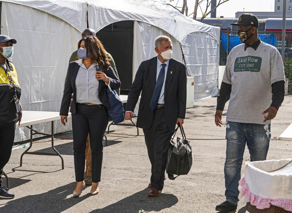 FILE - In this Feb. 4, 2021, file photo, Jeff Page, right, also known as General Jeff, a homelessness activist and leader in the Downtown Los Angeles Skid Row Neighborhood Council, walks with U.S. District Court Judge David O. Carter, middle, and Michele Martinez, special master on the issues of homelessness, after a court hearing at Downtown Women's Center in Los Angeles. A judge overseeing a sweeping lawsuit about homelessness in Los Angeles has ordered the city and county Tuesday, April 20, 2021, to find shelter for all unhoused residents of Skid Row within 180 days. Judge David O. Carter also ordered an audit of all funding related to the crisis of people living on the streets. (AP Photo/Damian Dovarganes, File)